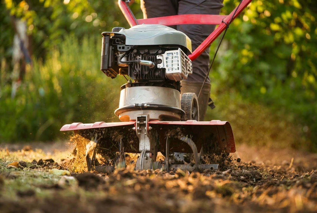 Motoazada trabajando sobre tierra suelta mientras sus fresas remueven y airean el suelo en un huerto o jardín.